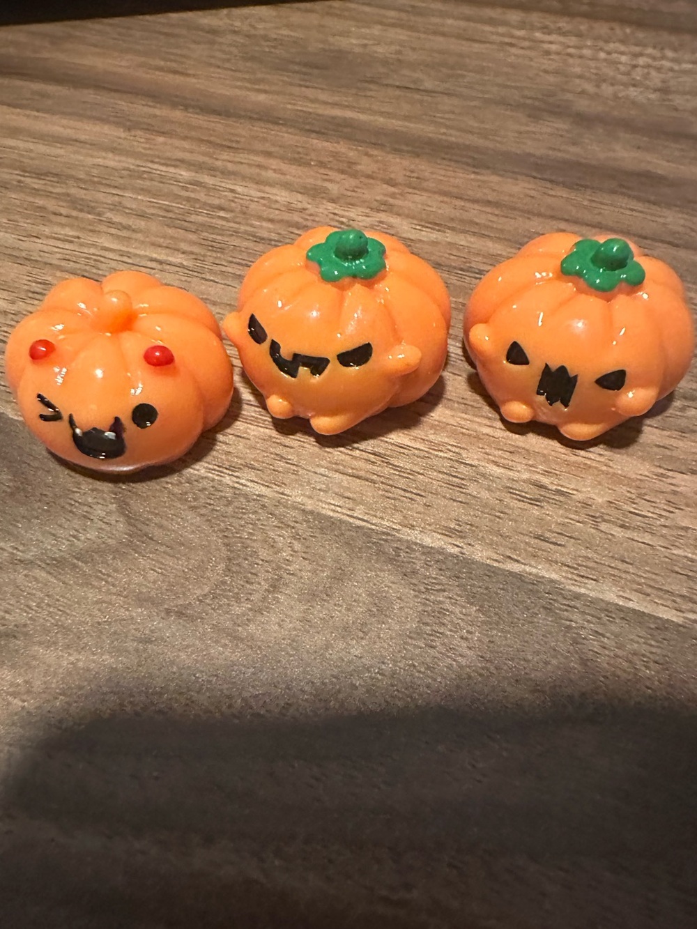 Orange pumpkin-shaped Halloween Mini figurines with green stems and faces